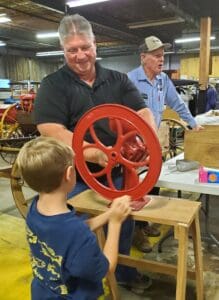 Young boy using old-time farm tool at the Fall Harvest Day in 2025